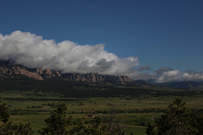 The Flatirons and the Rocky Mountains covered by clouds in Boulder Colorado Photo Credit Zack Neher